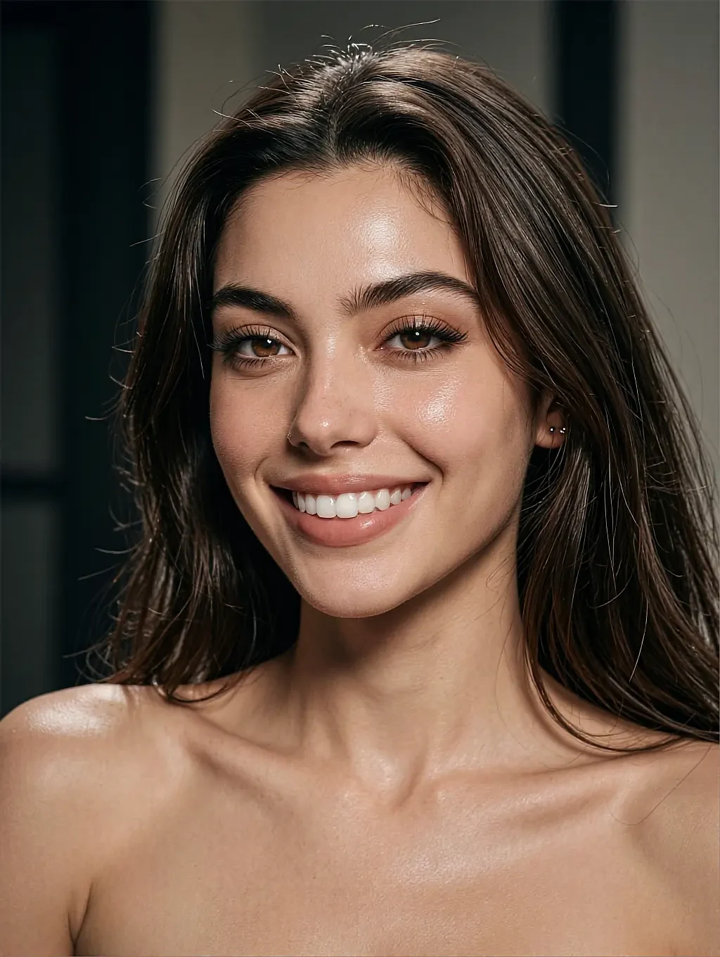 Brown shoulder-length hair, close-up smiling portrait with nose ring and bare shoulders, warm studio light